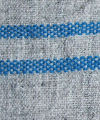 Rayed cloth produced with genuine woad dyed yarn set against a background of undyed natural grey